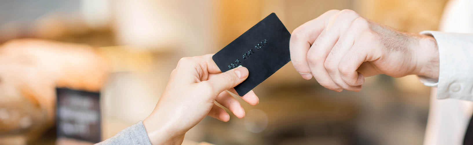 Person handing credit card to a sales person.