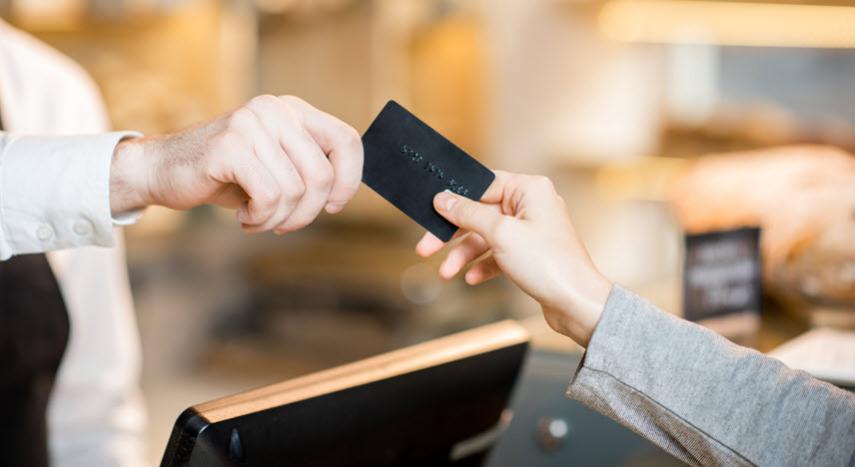 Sales associate taking a credit card from a buyer.